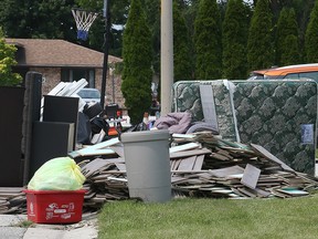 A pile of flood-damaged items sits on a curbside on Maplewood Drive in Lakeshore on July 19, 2021.