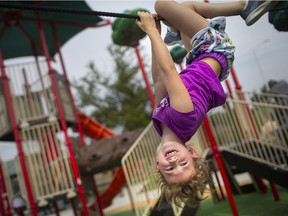 More clean water, more fun. Aria Bialek, 7, is all smiles as she hangs upside down on the new playground equipment at George Park on Friday, Aug. 13, 2021.