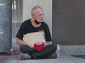 A man panhandles for money on Ouellette Avenue in downtown Windsor on Friday, August 20, 2021.