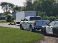 An Essex County OPP cruiser accompanies a provincial Ministry of Transportation enforcement officer conducting roadside commercial vehicle inspections.