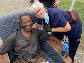Amherstburg nurse, Carolyn Davies, prepares a patient for transfer using a lounge chair due to wheelchair and stretcher shortages following the massive earthquake there on August 14.