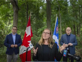 Karina Gould, Minister of International Development, is flanked by Irek Kusmiercyzk, MP for Windsor-Tecumseh, left, and Mayor of Windsor, Drew Dilkens, while announcing the signing of a statement of collaboration to explore the potential of a national urban park in the Ojibway Prairie Complex, on Monday, August 9, 2021.