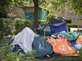 Tents and personal belongings fill the front yard of the recently condemned River Place in Sandwich Town on Thursday, August 5, 2021, as evicted tenants struggle to find places to live.