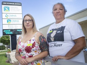 Andrea Milne, left, who lost a friend, Jordan Caine, to suicide in 2014, and Karen Peter, who's son, Bryce Peter, committed suicide on Father's Day in 2017, are pictured outside the Canadian Mental Health Association after a news conference announcing details for Suicide Awareness Month in September, on Wednesday, August 25, 2021.