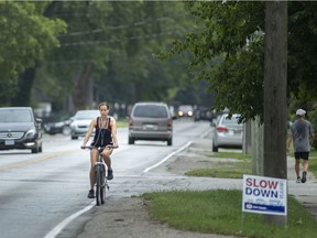A cyclist bikes along Riverside Drive East in Tecumseh, on Friday, Aug. 13, 2021.