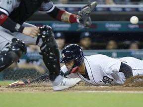 Victor Reyes #22 of the Detroit Tigers beats the throw to home plate to score against the Chicago White Sox on a sacrifice fly ball hit by Miguel Cabrera #24 during the third inning at Comerica Park on September 20, 2021, in Detroit, Michigan.