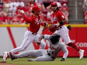 Kyle Farmer of the Cincinnati Reds turns a double play past Akil Baddoo of the Detroit Tigers in the third inning at Great American Ball Park on September 05, 2021 in Cincinnati, Ohio.