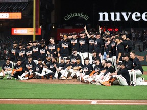 The San Francisco Giants pose for a team photo on the field after they clinched a playoff birth by beating the San Diego Padres at Oracle Park on September 13, 2021 in San Francisco, California.