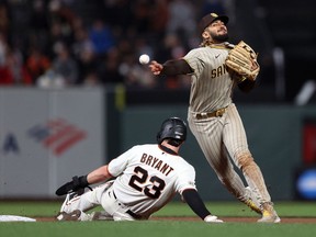 Fernando Tatis Jr. of the San Diego Padres attempts to turn a double play as Kris Bryant of the San Francisco Giants is forced out at second base in the fourth inning at Oracle Park on September 15, 2021 in San Francisco, California.