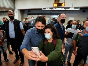 Prime Minister Justin Trudeau takes a selfie with a supporter, after the Liberals won a minority government, at the Jarry Metro station in Montreal September 21, 2021.