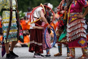 Hoop dancer Emilee Ann, left, hugs her friend Ayiana Myran as they wait to perform alongside other dancers at Toronto City Hall during the Every Child Matters walk in honour of children who lost their lives in Canada's Residential School system, in Toronto, Canada, on July 1, 2021.