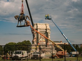 The statue of Robert E. Lee is lowered from its plinth at Robert E. Lee Memorial during its removal on Sept. 8, 2021 in Richmond, Va.