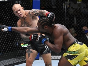 In this handout photo provided by UFC, Ryan Spann and Anthony Smith trade punches in a light heavyweight fight during the UFC Fight Night event at UFC APEX on September 18, 2021 in Las Vegas.
