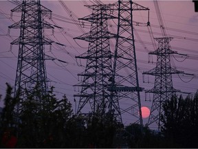 The sun sets behind electricity power pylons in Beijing on September 28, 2021.