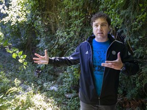 Ward 2 Coun. Fabio Costante surveys a very overgrown and neglected alley between Bridge and Partington avenues south of University Avenue West, on Tuesday, Sept. 28, 2021.