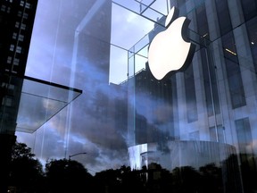 FILE PHOTO: The Apple Inc. logo is seen hanging at the entrance to the Apple store on 5th Avenue in Manhattan, New York, U.S., October 16, 2019.