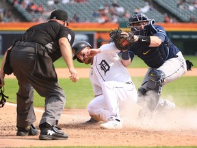 Detroit Tigers left fielder Robbie Grossman is tagged out by Tampa Bay Rays catcher Francisco Mejia during the eighth inning at Comerica Park.