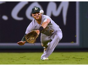 Oakland Athletics third baseman Chad Pinder dives for but cannot catch a ball hit for a double by Los Angeles Angels first baseman Jared Walsh (not pictured)  in the seventh inning at Angel Stadium.