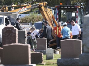 Individuals are shown at the Lakeview Cemetery in Leamington on Wednesday, September 29, 2021, where a body was exhumed from a decades old grave site.