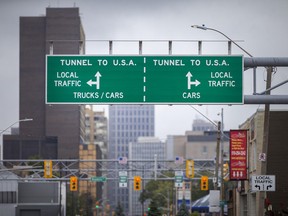 Signs directing travellers to the Detroit-Windsor Tunnel are seen on Tuesday, Sept. 21, 2021.  The American government has extended the closure of land crossings to non-essential travel due to the COVID-19 pandemic.