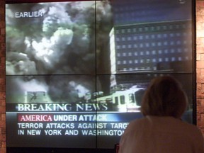 A delayed traveller at the Detroit Wayne County Airport watches television news coverage on Sept. 11, 2001.