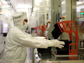 FILE PHOTO: A Bosch employee holds semiconductor wafer in a clean room in the company manufacturing base in Reutlingen near Stuttgart, Germany June 16, 2017.