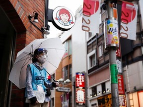 Woman who does street surveys wears a mask and a face shield, during a state of emergency amid the coronavirus disease (COVID-19) outbreak, in Tokyo, Japan August 29, 2021. REUTERS/Androniki Christodoulou