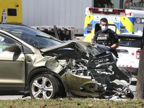 A Windsor officer checks out a damaged vehicle on Friday, September 10, 2021 at Huron Church and Malden roads. The motorist crashed into a traffic signal pole and levelled it. Injuries to the driver were not life threatening. No other vehicles were involved in the mishap which occurred at approximately 12:30 p.m.
