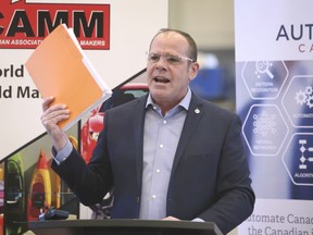 Chris Lewis, MP Essex holds up a petition during a press conference on Friday, March 19, 2021, at Cavalier Tool and Manufacturing Ltd. in Windsor. Lewis retained Essex in Monday's election but is in hospital after falling off a horse.