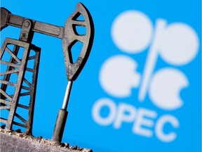A 3D-printed oil pump jack is seen in front of a displayed OPEC logo in this illustration picture, April 14, 2020