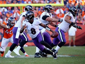 Quarterback Lamar Jackson of the Baltimore Ravens scrambles out of the pocket in the second half of the game against the Broncos at Empower Field At Mile High on October 03, 2021 in Denver.