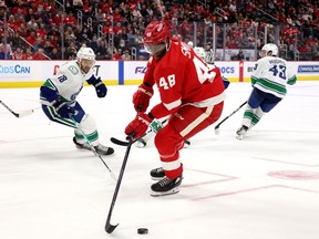 Givani Smith of the Detroit Red Wings controls the puck while playing the Vancouver Canucks at Little Caesars Arena on October 16, 2021 in Detroit, Michigan. Detroit won the game 2-1.