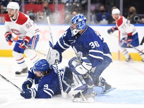 Maple Leafs' Justin Holl falls to the ice in front of goalie Jack Campbell in the first period against Montreal Canadiens at Scotiabank Arena on Wednesday, Oct. 13, 2021.