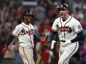 Atlanta Braves first baseman Freddie Freeman (right) celebrates with second baseman Ozzie Albies (left) after hitting a home run against the Milwaukee Brewers at Truist Park.