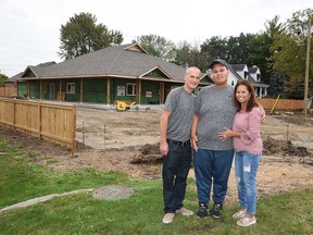 The Piunno family, Ernie, Christian and Susana stand in front of the nearly completed Family Respite Home on Howard Ave.