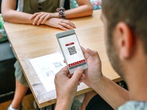 A customer scans a restaurant menu QR code on the table.