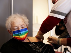 An elderly woman receives a booster shot of her vaccination against COVID-19 at an assisted living facility, in Netanya, Israel, Jan. 19, 2021.