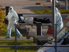 Medical specialists transport a patient outside a hospital for people infected with COVID-19 in Moscow, Oct. 6, 2021.