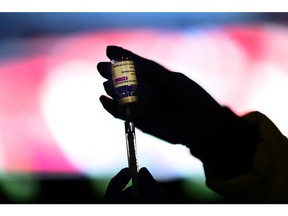 In this file photo a health worker prepares a dose of the AstraZeneca/Oxford vaccine at a coronavirus vaccination centre at at the Wanda Metropolitano stadium in Madrid on March 24, 2021.
