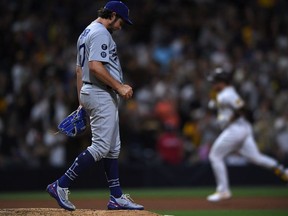 Los Angeles Dodgers starting pitcher Trevor Bauer (left) looks on from the mound after a home run hit by San Diego Padres catcher Victor Caratini (right) during the seventh inning at Petco Park.
