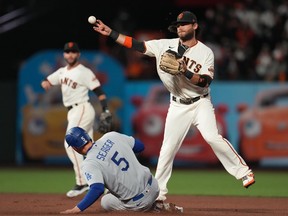 Los Angeles Dodgers shortstop Corey Seager is out at second in a double play against San Francisco Giants shortstop Brandon Crawford in the fourth inning during game one of the 2021 NLDS at Oracle Park.