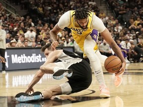 Los Angeles Lakers forward Anthony Davis attempts to control the loos ball above San Antonio Spurs forward Drew Eubanks in the second half at AT&T Center.