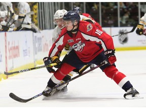 Windsor Spitfires' Daniil Sobolev (10) checks Sarnia Sting's Nolan Dann in the first period at Progressive Auto Sales Arena in Sarnia on Friday.