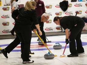 TECUMSEH, ON. Thursday, Oct. 14, 2021 -- Phil Denis and daugher Laura Beneteau, members of the Beach Grove curling team, sweep during the Ontario Mixed Curling Championship at Beach Grove Golf and Curling Club in Tecumseh on Thursday, Oct. 14, 2021.