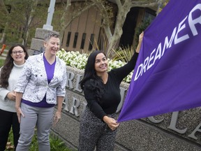 Nour Hachem-Fawaz, right, founder and president, Build a Dream, is joined by Jaquelyn Bezaire, left, and Victoria Rose, as they raise the Dreamer Day flag at Charles Clark Square on Tuesday, Oct. 5, 2021.
