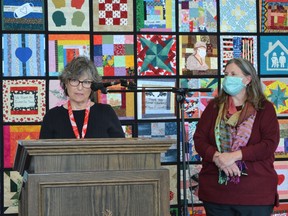 Patricia Savage, left, and Rebecca Rudman, co-founders of the Windsor Essex Sewing Force, speak about the community quilt created by the Windsor Essex Sewing Force and exhibited in the lobby of Windsor City Hall on Thursday, Oct. 28, 2021.