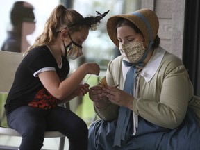 Willow Thomas-Lightfoot, left, gets a hand from Samantha Keller, an interpreter at the John R. Park Homestead, on Sunday, Oct. 3, 2021. They were making crafts from corn husks.