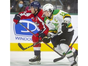 Windsor Spitfires' captains Will Cuylle, left, battles with London Knights' captain Luke Evangelista during Friday's game at Budweiser Gardens.