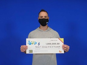 Steven Todesco of Tecumseh holds up a prize cheque from the OLG. Todesco was part of a group of 16 people who bought a Lotto MAX ticket.
