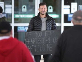 Windsor-born Zachery Dereniowski (mdmotivator on TikTok) holds one of his signs outside the Devonshire Mall in Windsor on Oct. 26, 2021.